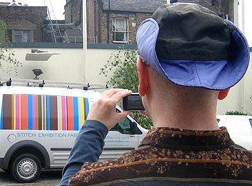 Me in London, June 2005 Seen from behind, I photograph a colourful minivan as I wear my purple hat and striped shirt